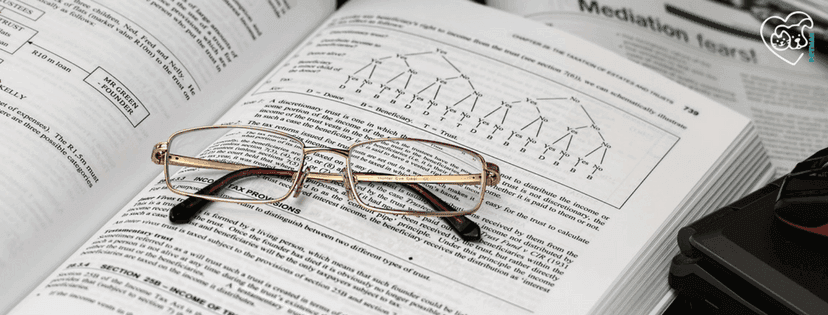 aufgeschlagenes wissenschaftliches Buch mit Brille drin